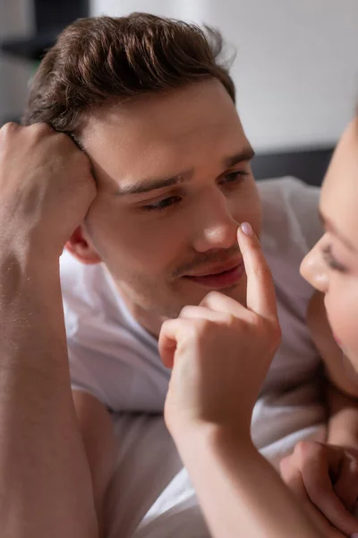 Selektiver Fokus des Mädchens, das Nase des hübschen Freundes im Schlafzimmer berührt — Stockfoto