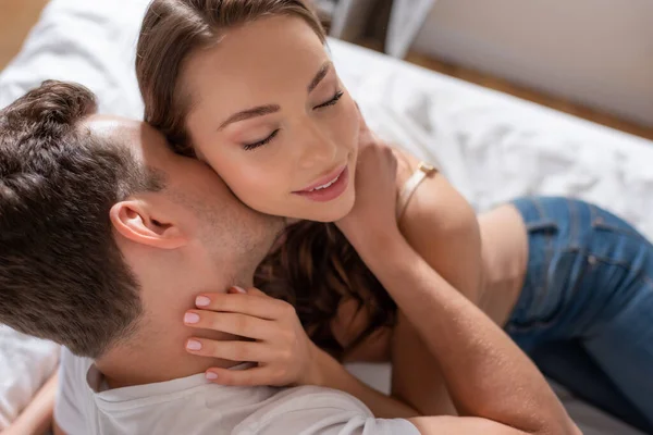 Young man kissing happy girlfriend with closed eyes — Stock Photo