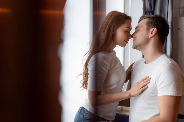 Selektiver Fokus eines gutaussehenden Mannes in der Nähe einer schönen Frau zu Hause — Stockfoto