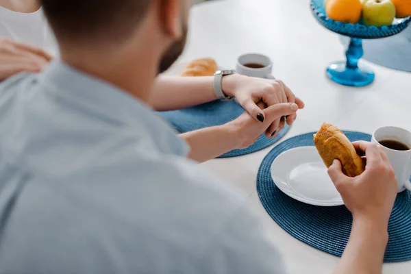 Cropped view of boyfriend and girlfriend holding hands in kitchen — Stock Photo