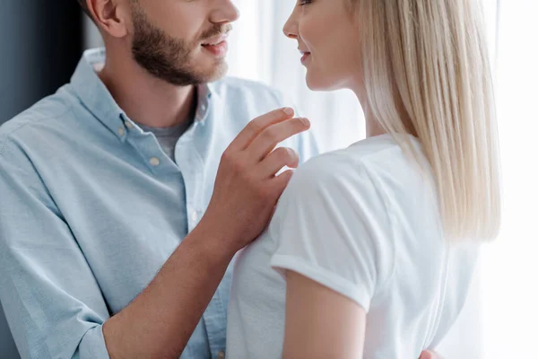 Recortado vista de feliz novia cerca barbudo novio en casa - foto de stock