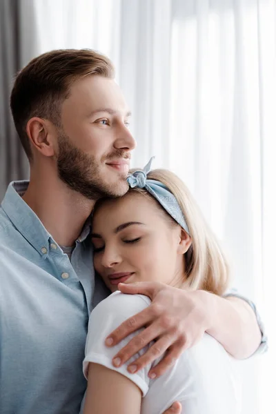 Homem feliz abraçando namorada alegre em casa — Fotografia de Stock