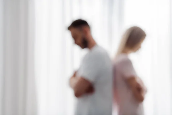 Blurred view of man and woman standing with crossed arms, relationship difficulties concept — Stock Photo