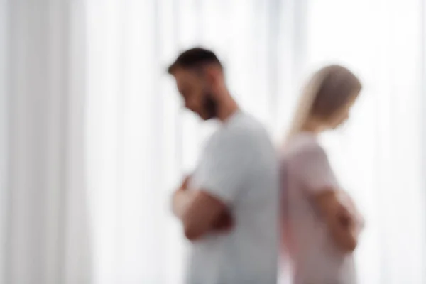 Visión borrosa del hombre y la mujer de pie con los brazos cruzados, concepto de dificultades de relación - foto de stock