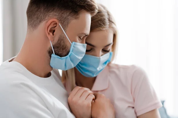 Селективное внимание девушки и мужчины в медицинских масках дома — стоковое фото