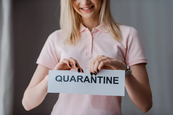 Ausgeschnittene Ansicht einer glücklichen Frau, die Papier mit Quarantäne-Schriftzug zerreißt — Stockfoto