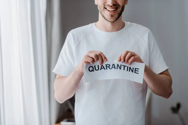 Vue recadrée de l'homme heureux déchirant du papier avec lettrage de quarantaine — Photo de stock