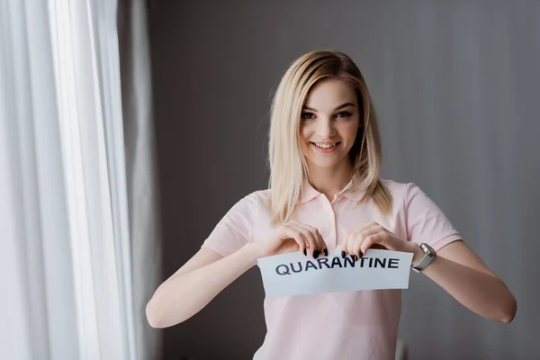 Femme heureuse déchirant du papier avec lettrage de quarantaine — Photo de stock