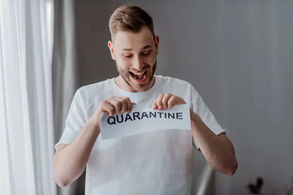 Homme excité déchirant du papier avec lettrage de quarantaine — Photo de stock