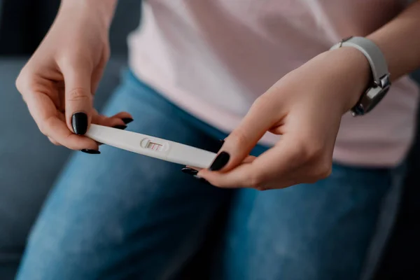 Vista ritagliata della ragazza che tiene il test di gravidanza con risultato positivo — Foto stock