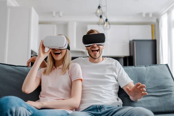 Fröhliches Paar in Virtual-Reality-Headsets zu Hause — Stockfoto