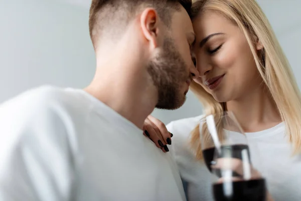 Foco seletivo de homem feliz e mulher com olhos fechados segurando óculos com vinho tinto — Fotografia de Stock