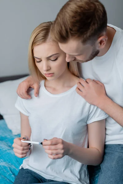 Uomo barbuto e frustrato fidanzata guardando test di gravidanza — Foto stock