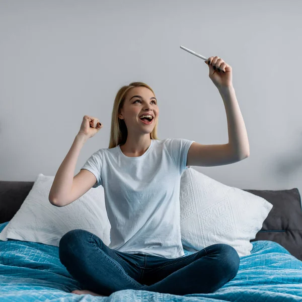 Excited and pregnant woman holding pregnancy test with positive result — Stock Photo