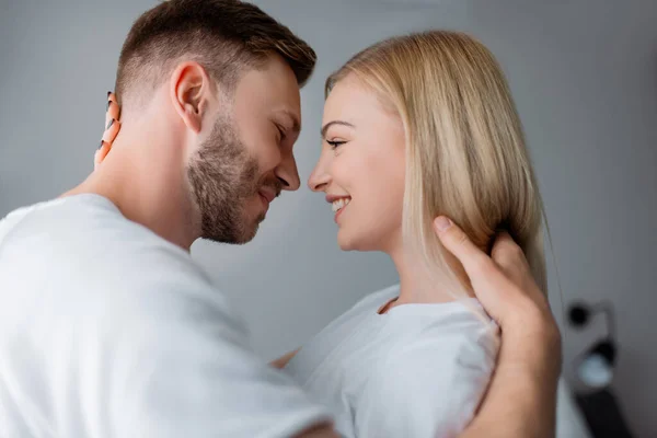 Seitenansicht eines fröhlichen Paares, das einander ansieht und dabei lächelt — Stockfoto