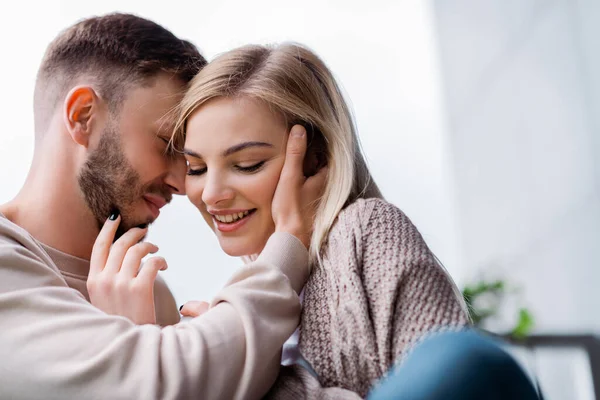 Messa a fuoco selettiva di uomo barbuto toccare ragazza allegra e bella — Foto stock