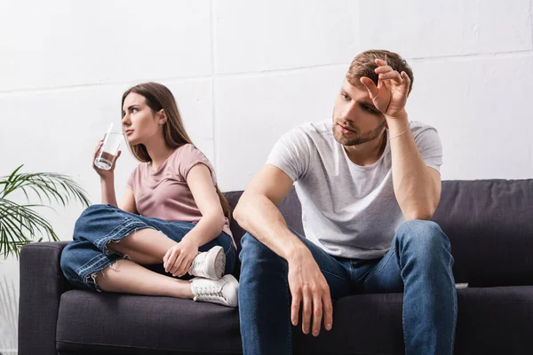 Sad emotional couple with glass of water at home during summer heat — Stock Photo