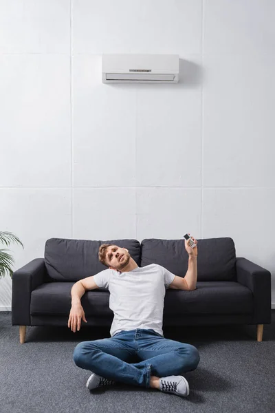 Homem exausto sentindo-se desconfortável com ar condicionado quebrado em casa durante o calor do verão — Fotografia de Stock