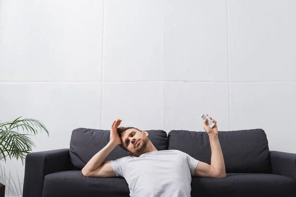 Homem cansado sentindo-se desconfortável com ar condicionado quebrado em casa durante o calor do verão — Fotografia de Stock
