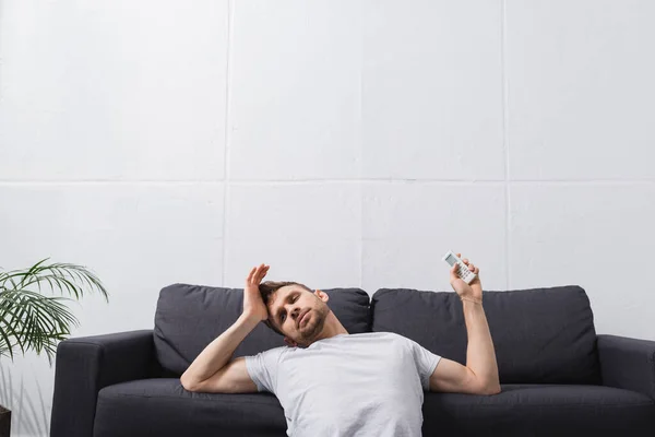 Tired man feeling uncomfortable with broken air conditioner at home during summer heat — Stock Photo