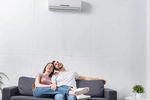 Heureux couple émotionnel à la maison avec climatiseur — Photo de stock