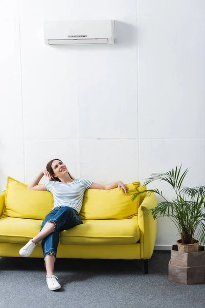 Felice donna sentirsi a proprio agio con condizionatore d'aria a casa durante il caldo estivo — Foto stock