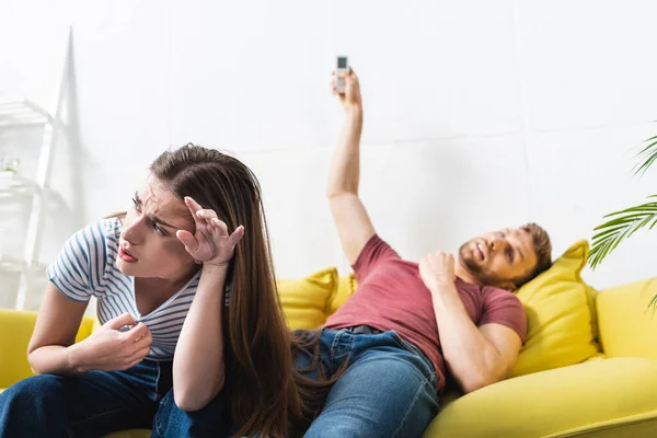 Chateado casal sofrendo de calor enquanto sentado em casa com ar condicionado quebrado — Fotografia de Stock