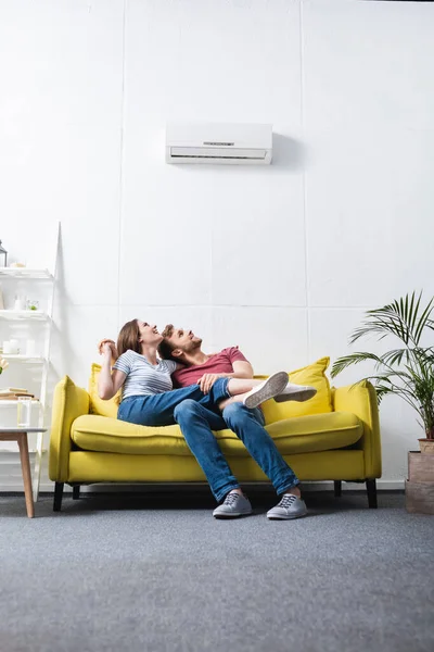 Happy couple at home with air conditioner — Stock Photo