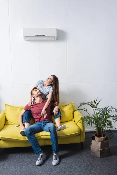 Feliz pareja en casa con aire acondicionado - foto de stock