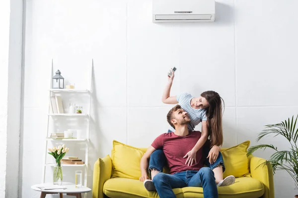 Heureux couple émotionnel étreignant à la maison avec climatiseur — Photo de stock