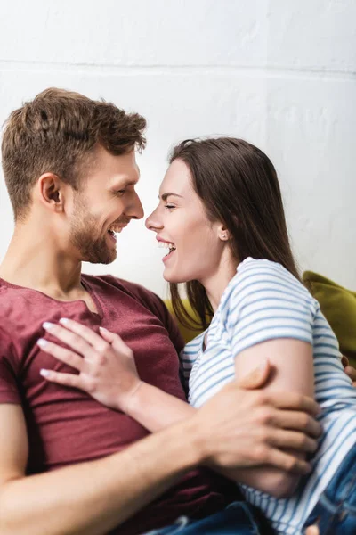 Rindo bela jovem casal abraçando em casa — Fotografia de Stock