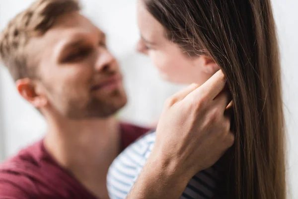 Feliz hermosa joven pareja abrazando en casa, enfoque selectivo - foto de stock