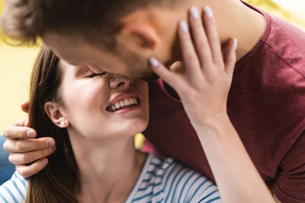 Sonriente joven pareja abrazando y yendo a besar en casa - foto de stock