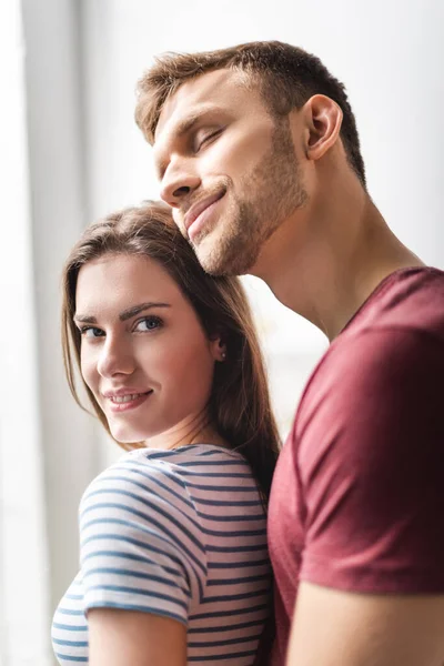 Schönes lächelndes junges Paar, das sich zu Hause umarmt — Stockfoto