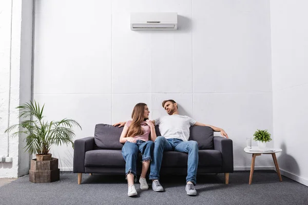 Молода пара страждає від спеки, сидячи вдома з розбитим кондиціонером — стокове фото