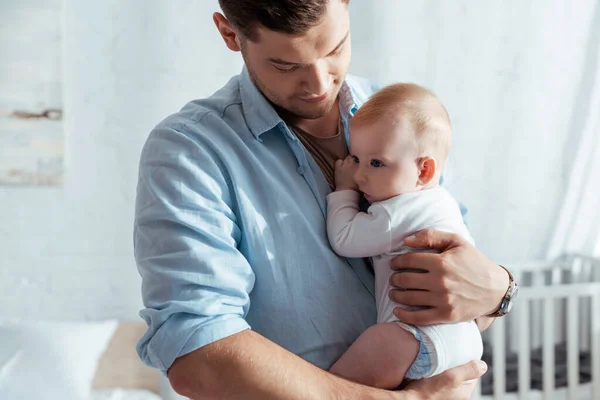 Junger Mann hält sich an Händen und umarmt entzückenden kleinen Sohn — Stockfoto