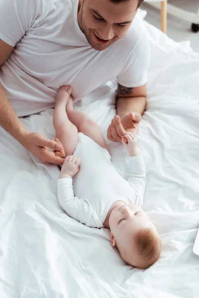 Vista aerea di felice padre toccando le mani di adorabile piccolo figlio — Foto stock
