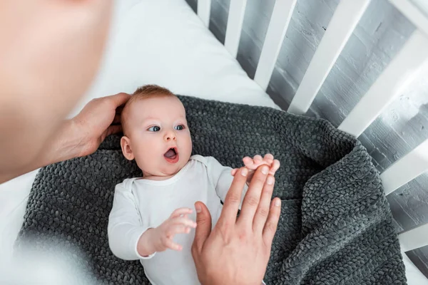 Visão cortada do homem tocando a mão do menino bebê surpreso, foco seletivo — Fotografia de Stock