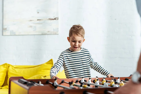 Ausgeschnittene Ansicht eines Mannes, der mit aufgeregtem Sohn Tischkicker spielt — Stockfoto