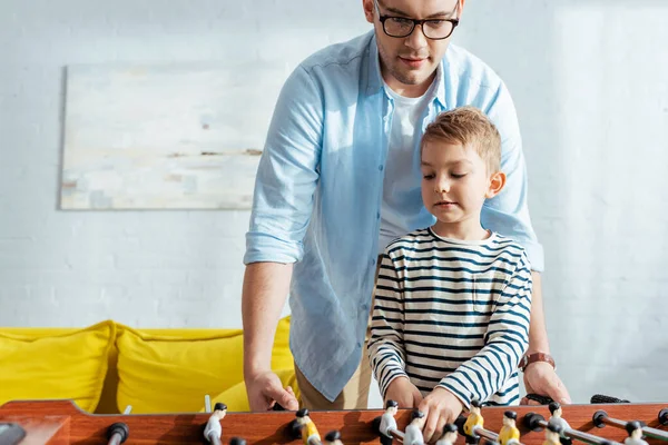 Aufmerksame Vater und Sohn beim Tischkicker zu Hause — Stockfoto