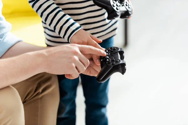 КИІВ, УКРАЇН - 9 ЧЕРВНЯ 2020 року: поганий погляд на батька, який показує, як користуватися джойстиком для сина. — стокове фото