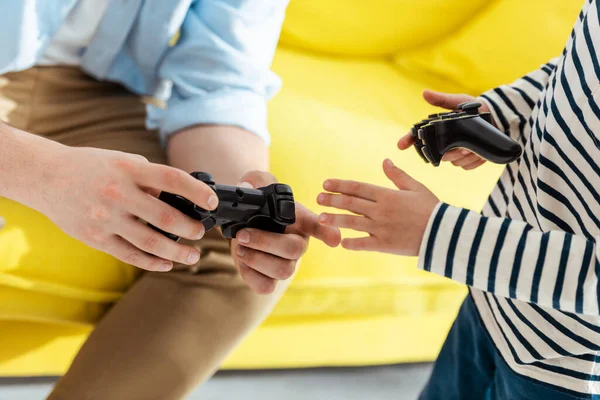 KYIV, UKRAINE - JUNE 9, 2020: cropped view of man showing how to operate joystick to son — Stock Photo