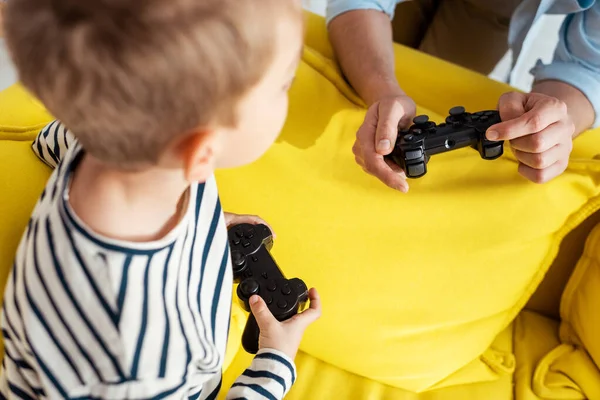 KYIV, UKRAINE - JUNE 9, 2020: cropped view of man showing joystick to attentive son — Stock Photo