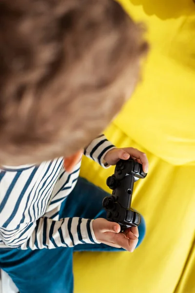 KYIV, UCRANIA - 9 de junio de 2020: vista aérea del niño jugando videojuego con joystick - foto de stock