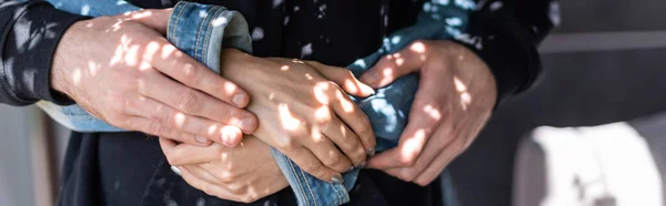 Cosecha panorámica del hombre abrazando novia al aire libre - foto de stock