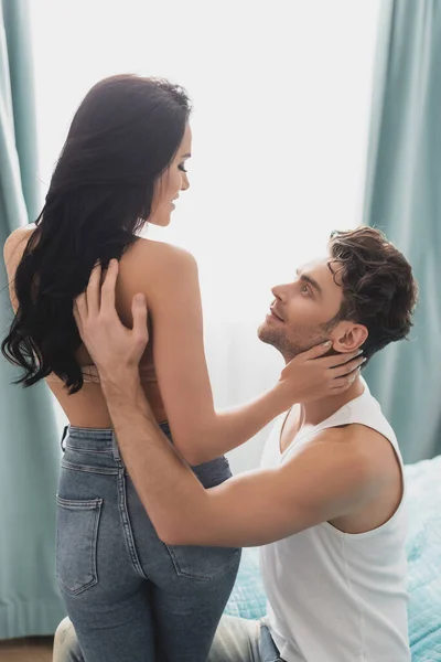 Bello uomo toccare indietro di seducente fidanzata su letto — Foto stock