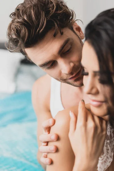 Selective focus of handsome man touching girlfriend in bedroom — Stock Photo