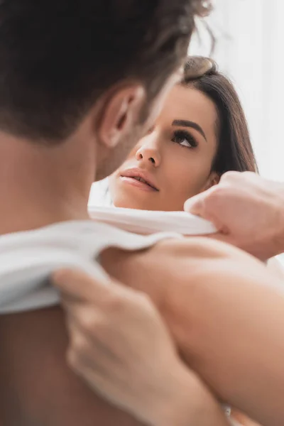 Selective focus of woman undressing boyfriend at home — Stock Photo