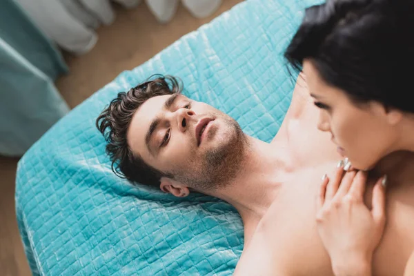 Vista aerea dell'uomo senza maglietta che guarda la ragazza sul letto — Foto stock