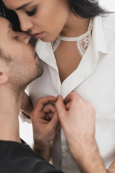 Selective focus of man unbuttoning shirt and kissing beautiful girlfriend — Stock Photo